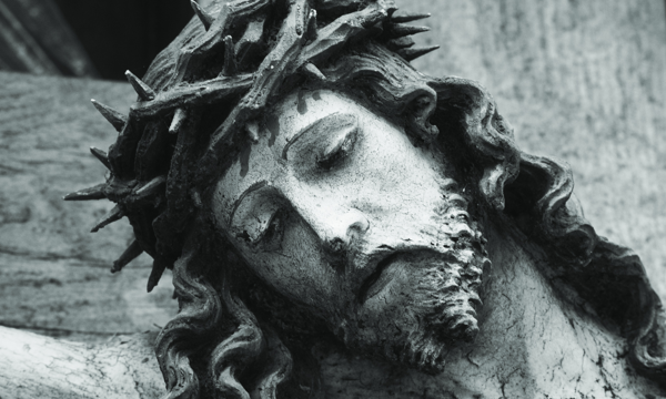 Mit Dornenkrone gekröntes und geneigtes Haupt Jesu am Kreuz