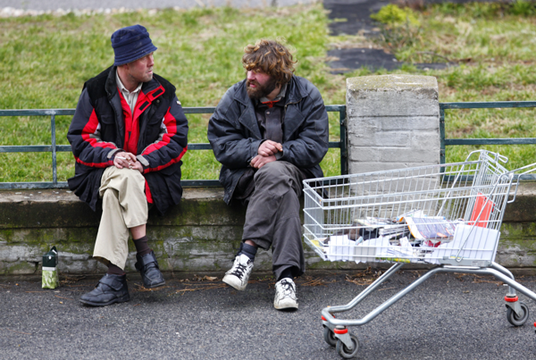 Zwei Obdachlose im Gespräch und ein Einkaufskorb