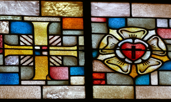 Buntglasfenster: Links Kreuz und rechts Lutherrose