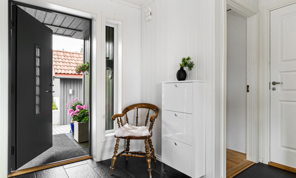 Blick vom Flur durch eine geöffnete Eingangstür auf nach draußen.