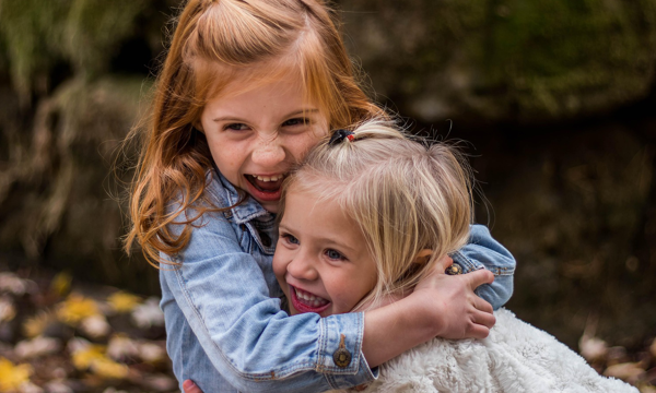 zwei lachende Kinder, die sich umarmen