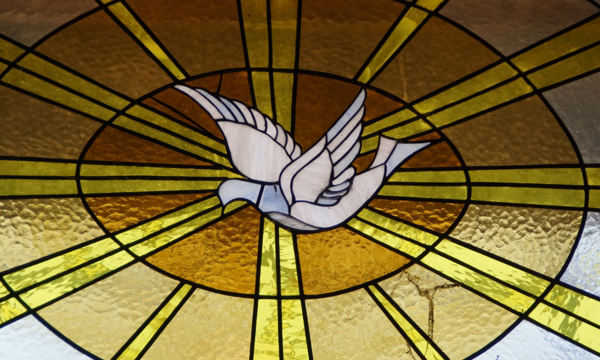 Glasfenster mit einer fliegenden Taube als Symbol des Heiligen Geistes